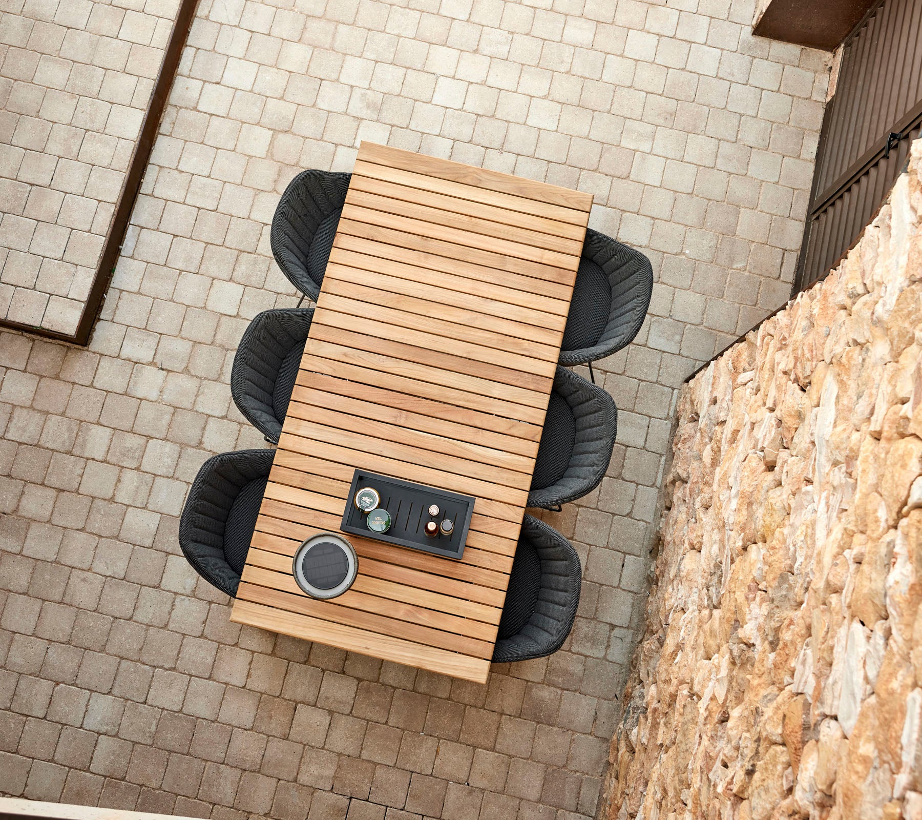 Ein modernes Holztisch mit vier stilvollen schwarzen Stühlen, mit einer zentralen Anordnung von Getränken und Snacks.