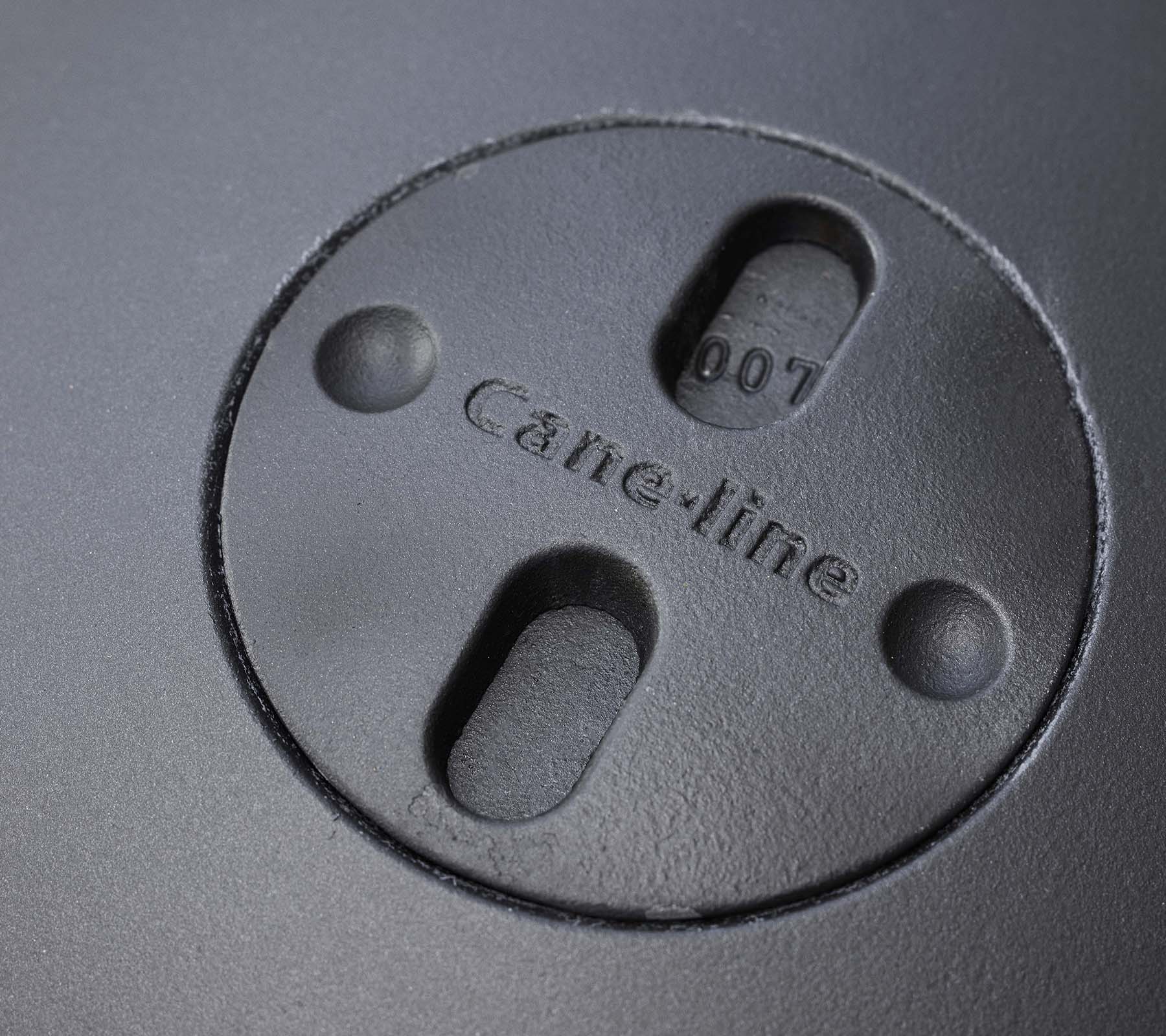 Nahaufnahme eines kreisförmigen Elements mit eingraviertem "Cane-line" Logo und zwei Schlitzen, Teil eines Feuerschalen-Designs.