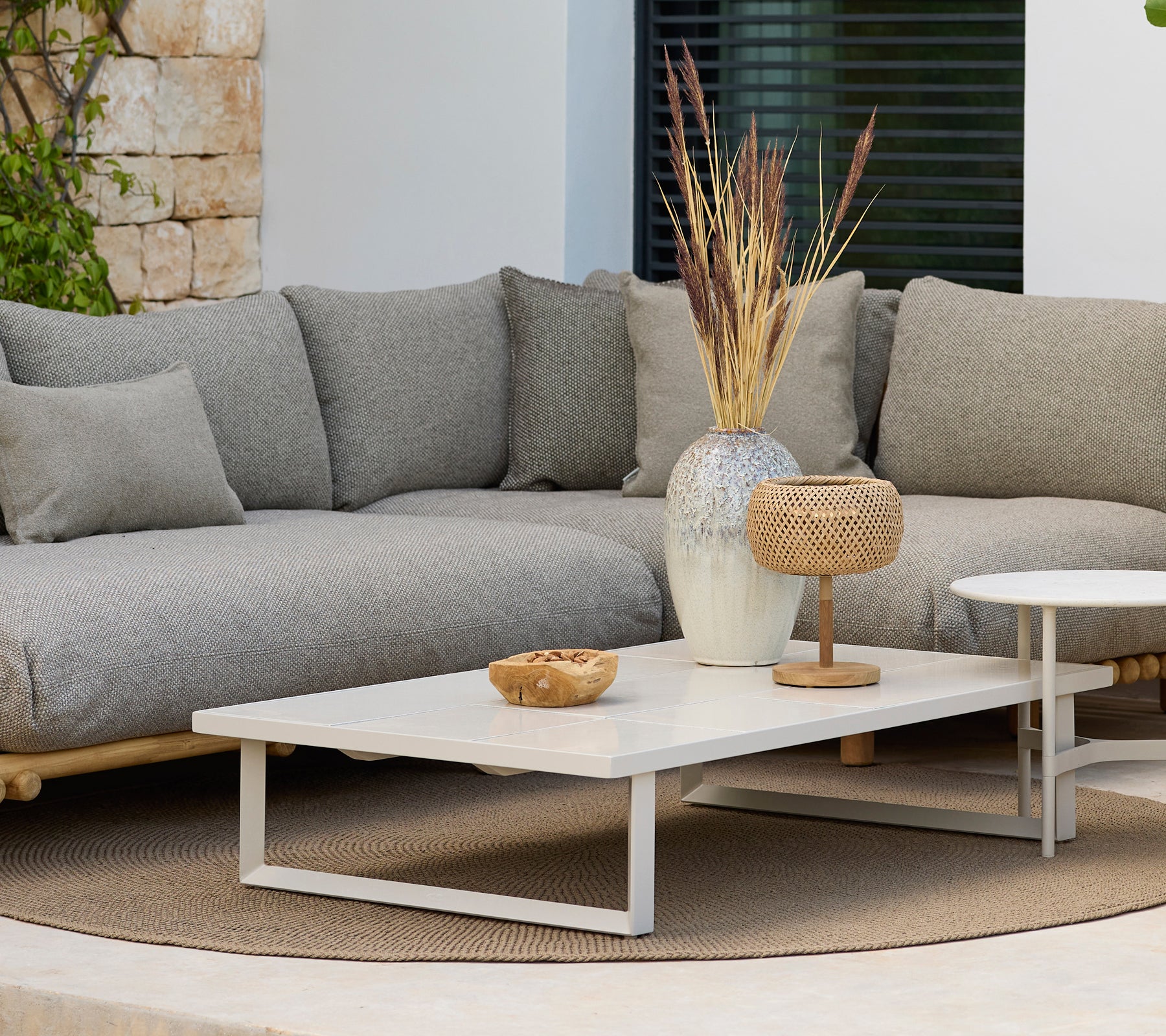 Moderner Lounge-Bereich mit einem grauen Sofa und einem weißen Couchtisch mit Dekoration.