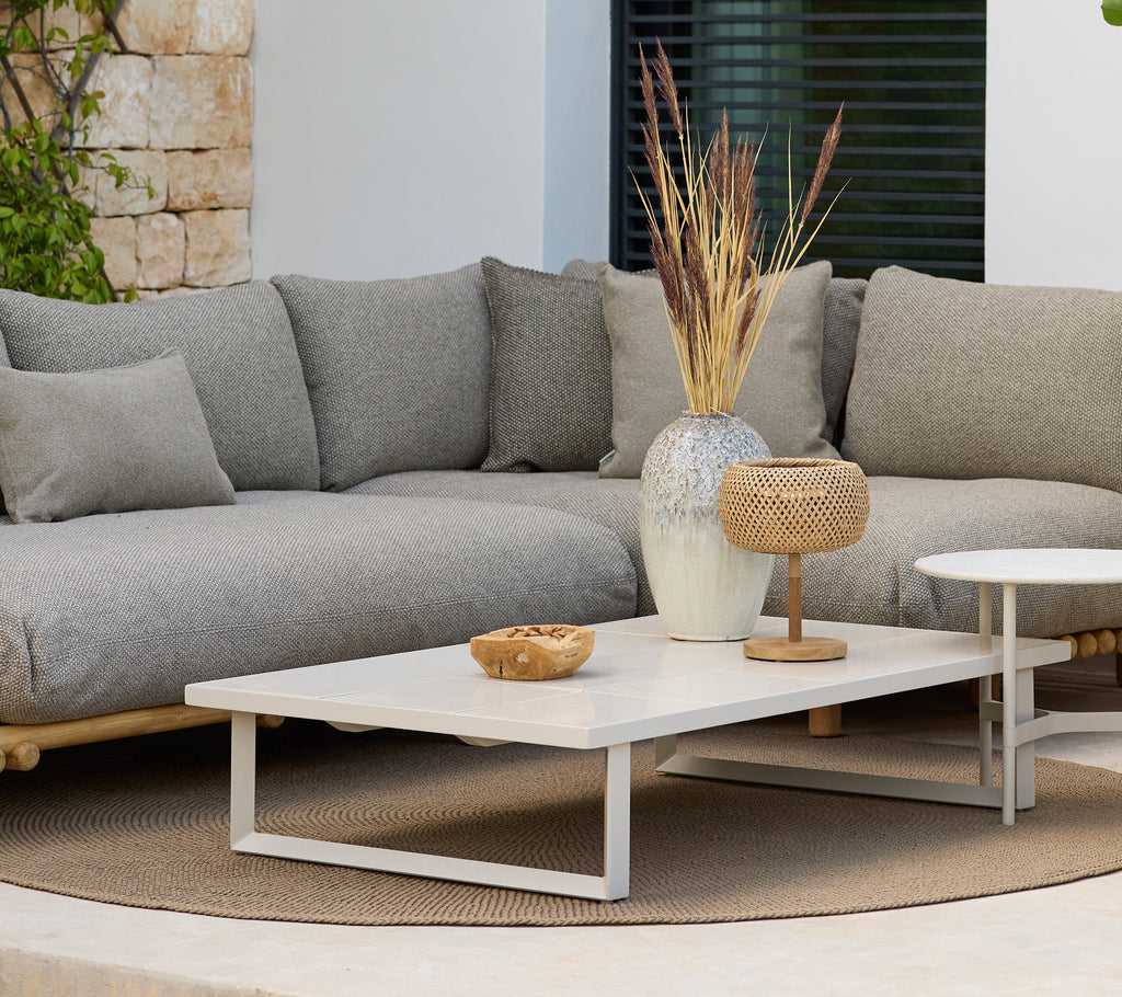 Moderner Lounge-Bereich mit einem grauen Sofa und einem weißen Couchtisch mit Dekoration.