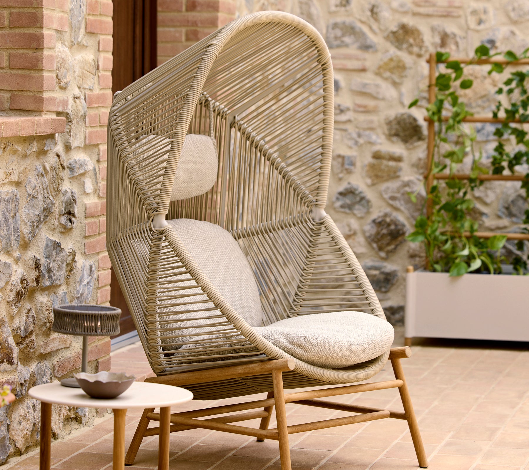 Stylischer Hive-Stuhl in Sandfarbe mit einem einzigartigen Twist-Design, ergänzt durch plüschige Kissen für Komfort.