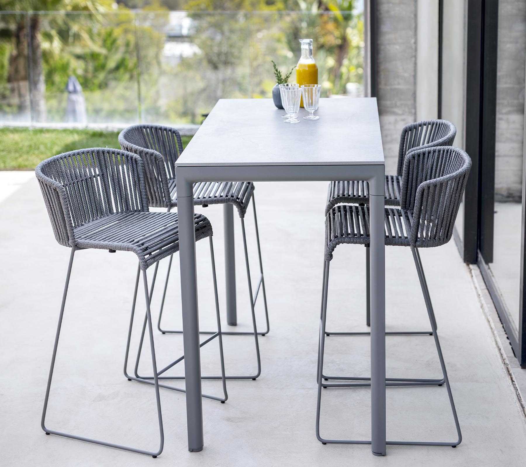 Moderne Esszimmer-Satz mit einem eleganten Tisch und vier hochlehnigen Stühlen mit minimalistischem Design, ideal für ungezwungene Zusammenkünfte.