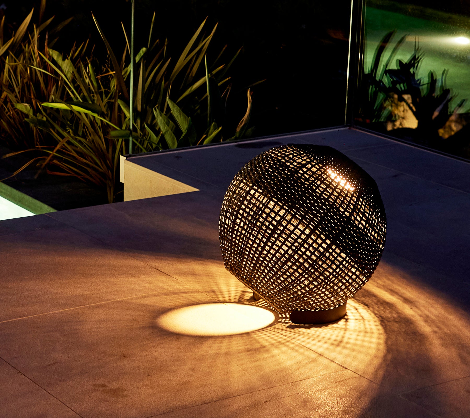 Eine runde Illusionslampe, die komplizierte Lichtmuster auf die Oberfläche wirft und eine fesselnde Atmosphäre erschafft.