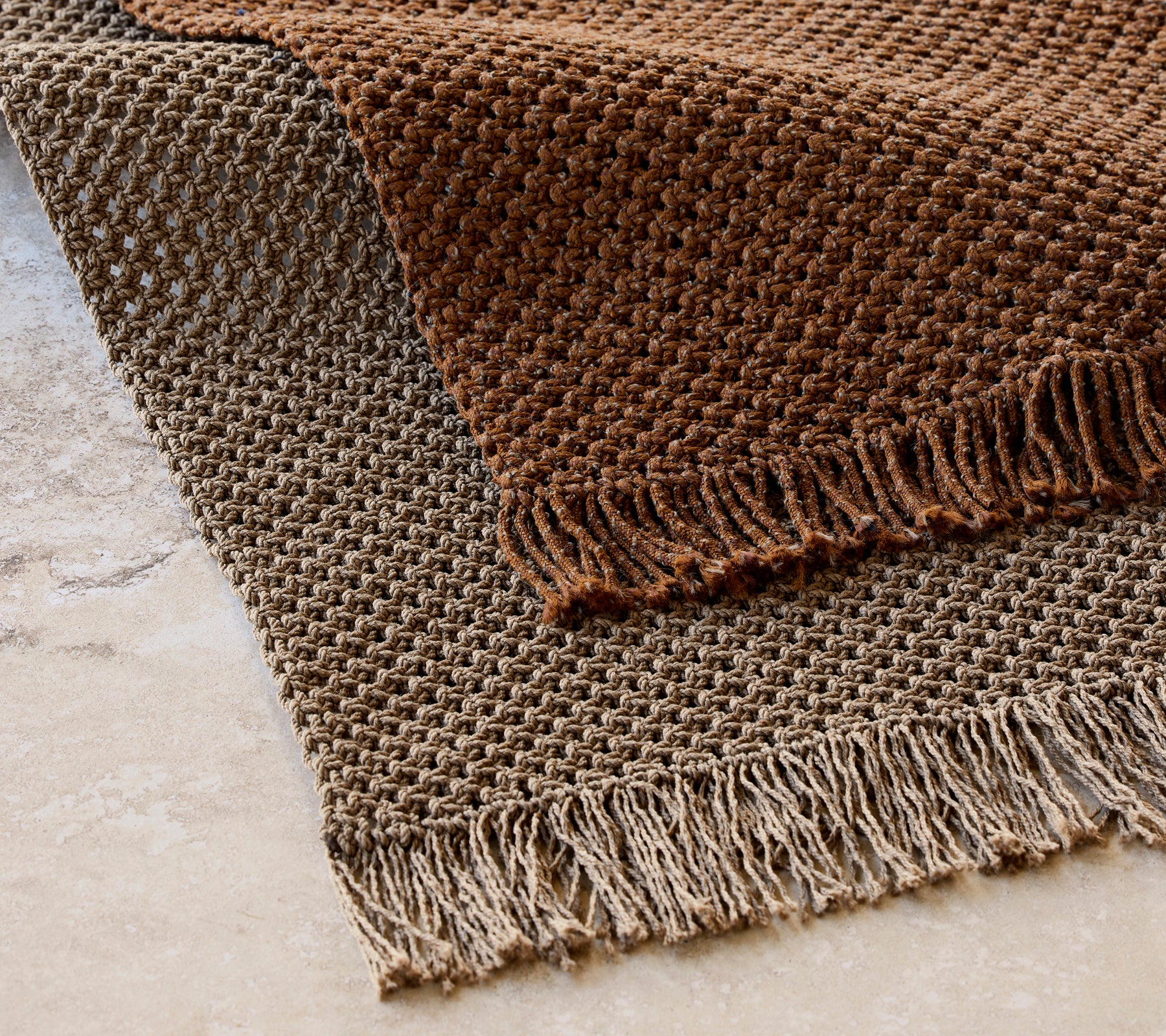 Gestrickter Teppich mit den Maßen 240x170 cm in einem strukturierten Muster mit Fransen, in warmen Brauntönen.