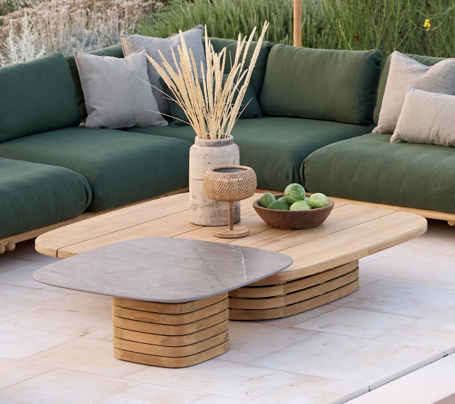 Modernes Lounge-Bereich mit einem grünen Sofa mit Kissen, einem Holztisch und dekorativen Gegenständen.