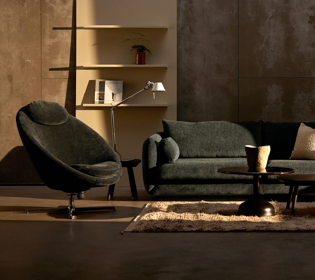 A dark green chenille Pace chair and Bloom 3-seater sofa are arranged alongside a coffee table on a soft rug, creating a cozy seating area.