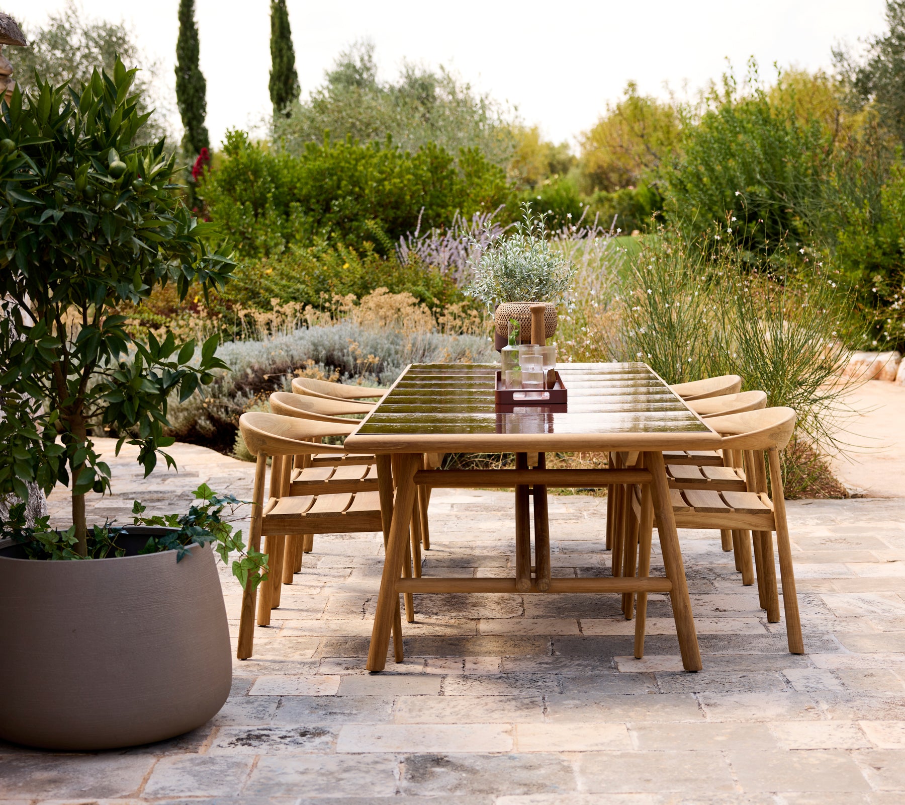 Modernes Esszimmer-Tisch im Freien mit Holzstühlen in einem Gartenambiente.