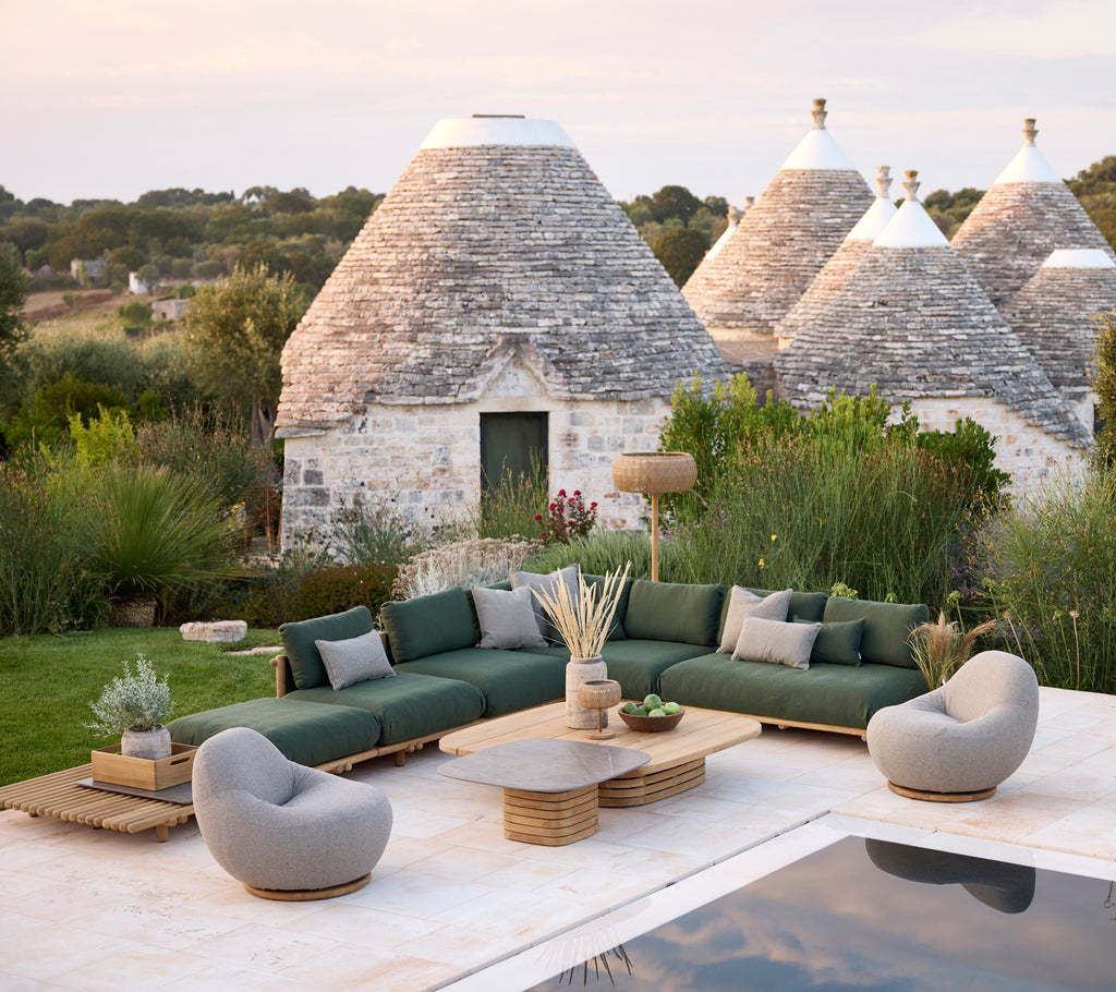 Modernes Outdoor-Lounge-Bereich mit grünem Ecksofa, grauen Sessel und Tisch aus Holz.