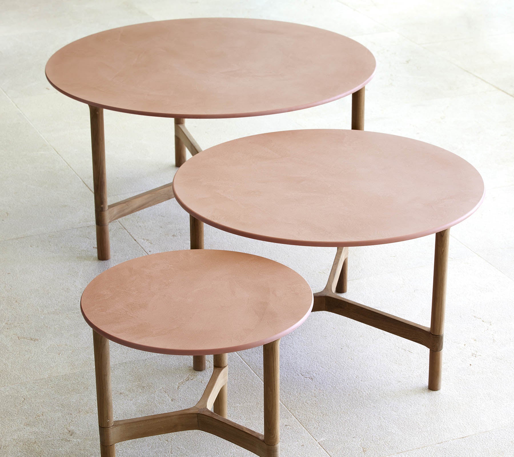 Drei runde Couchtische in unterschiedlichen Größen mit einem minimalistischen Design und Holzbeinen sowie einer glatten, eleganten Oberfläche.
