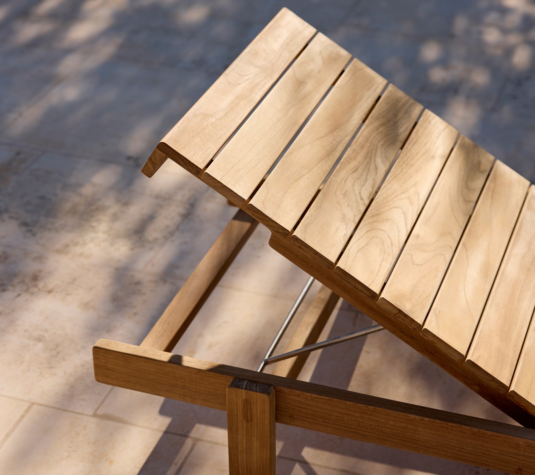 Moderner Holz-Lounge-Stuhl mit verstellbarem Rückenlehne auf einer sonnigen Terrasse.