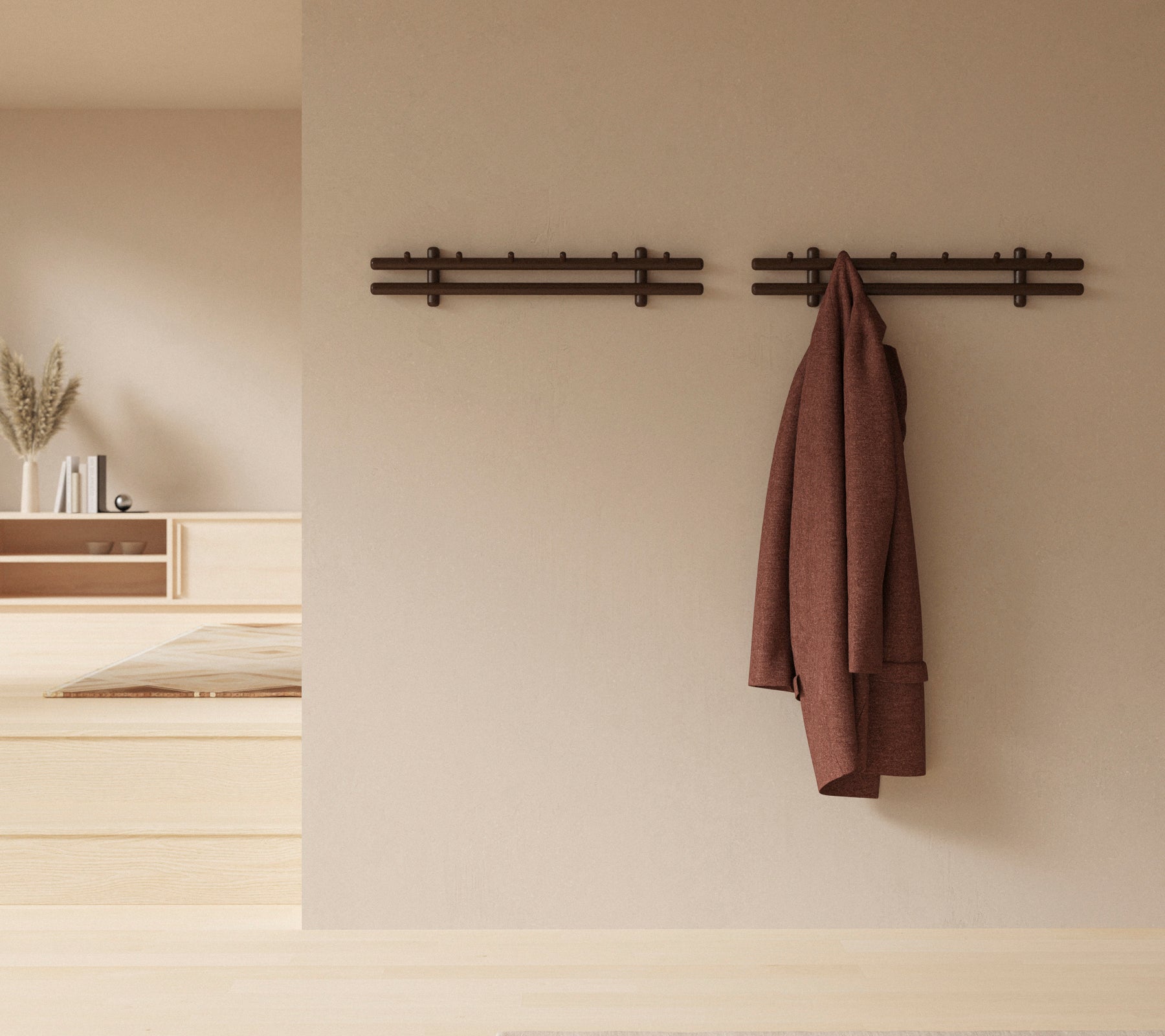 Ein minimalistisches Wanddisplay mit Holzstäben, die einen Mantel und eine Sammlung von Lappen halten, wodurch die rustikale Dekorästhetik verbessert wird.