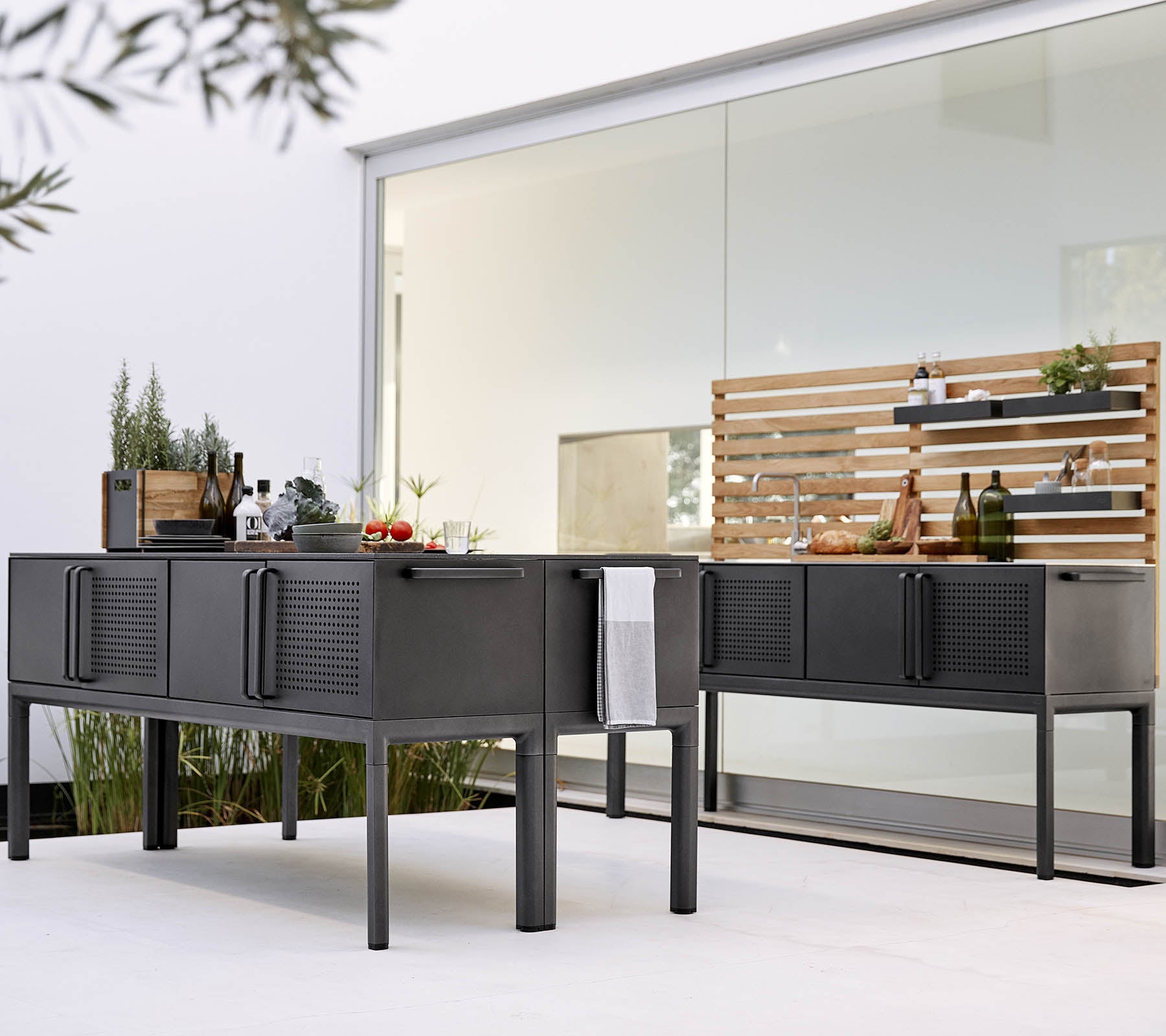 Moderne Außenkücheneinrichtung mit eleganten, schwarzen Schränken und einem Holzregal zur Aufbewahrung und Präsentation.